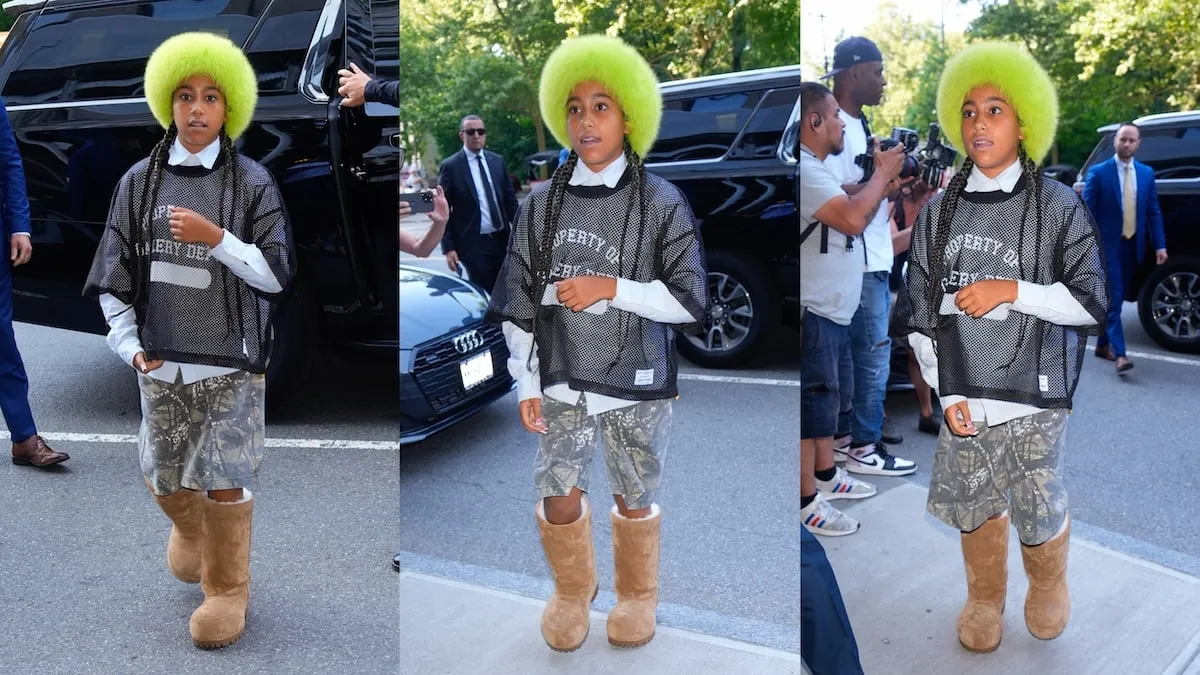 Wearing a lime green furry hat and camo shorts, North West enters an NYC building