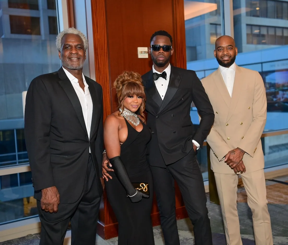 Charles Oakley, Phaedra Parks, her date, and a guest stand together for a photo at a 2024 Charles Oakley Foundation event