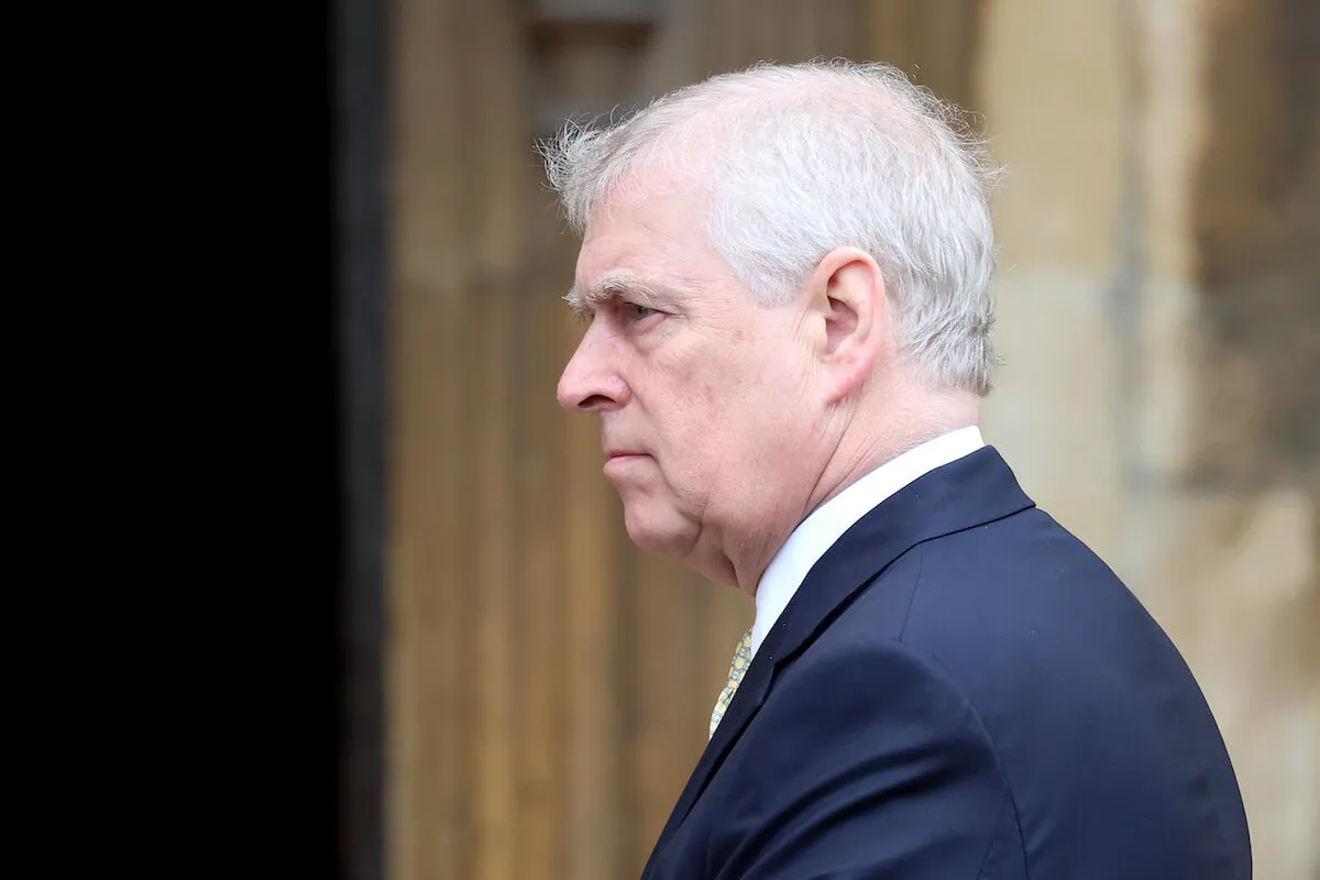 Prince Andrew, who needs to let the Royal Lodge and 'quietly disappear,' looks on wearing a suit.