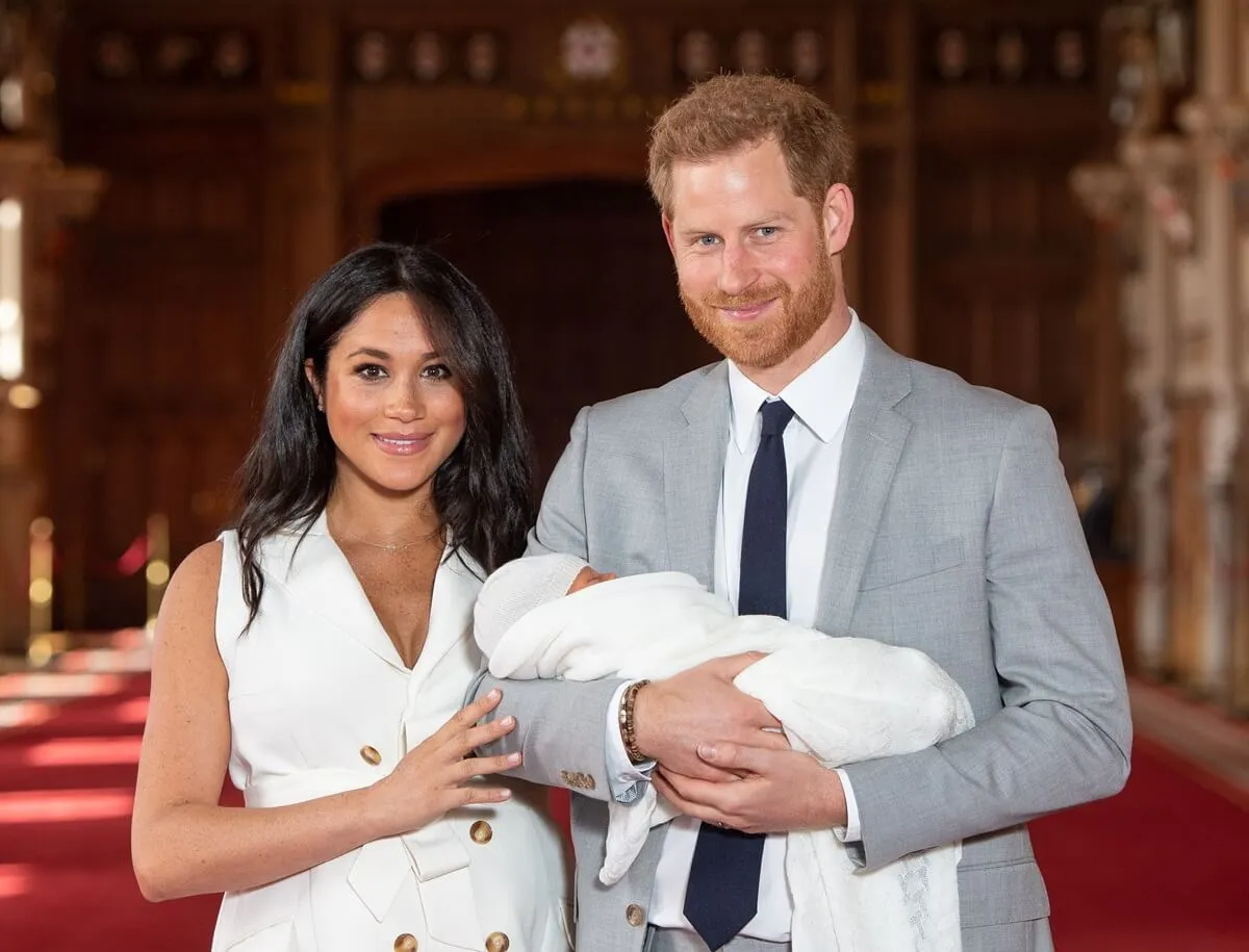 Prince Harry and Meghan Markle pose with their newborn son, Archie, during a photocall in St. George's Hall at Windsor Castle