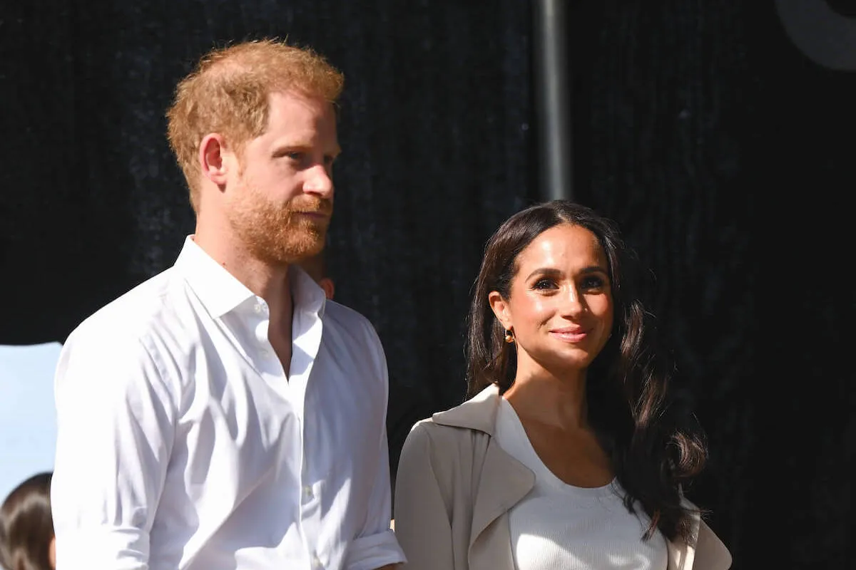 Prince Harry and Meghan Markle, whose CBS Sunday Morning inerview doesn't indicate they want to heal the royal rift, per an author, stand next to each other