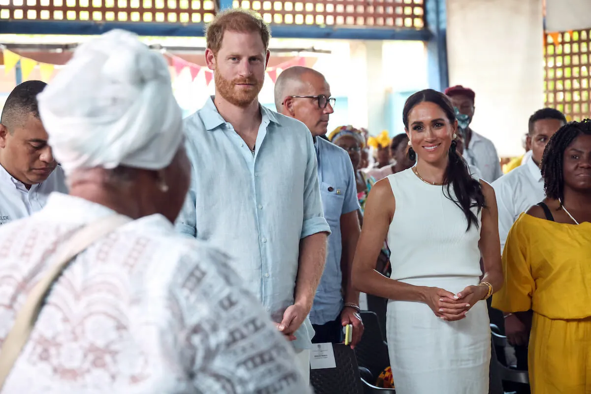 Prince Harry, whose 'Spare' memoir is being released in paperback, stands next to Meghan Markle