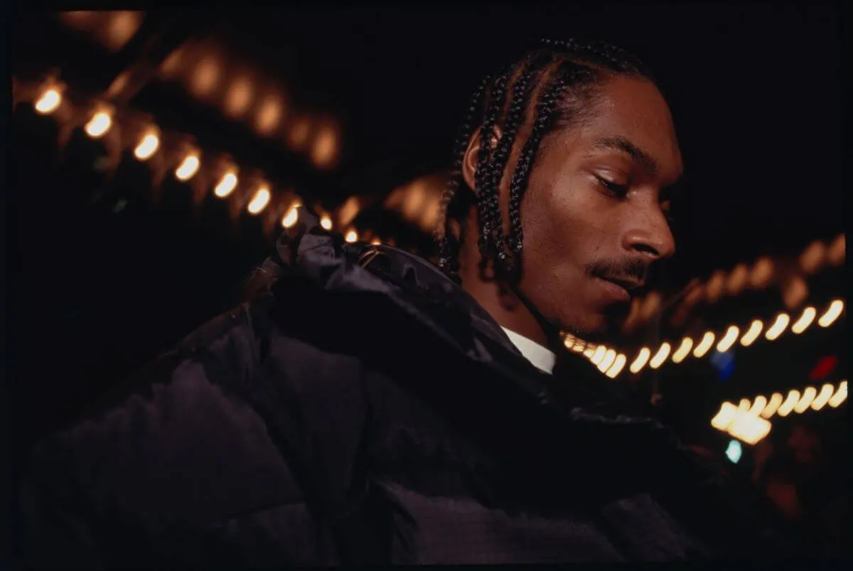 Snoop Dogg wears black and stands in profile.