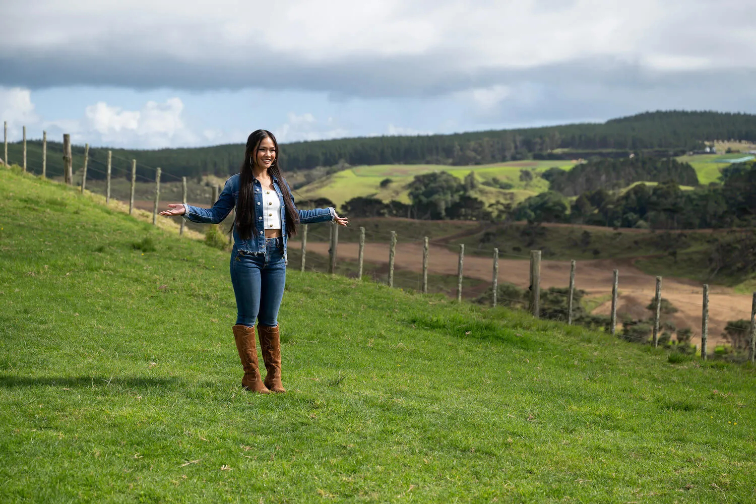 Jenn Tran standing in a field alone with her arms out in 'The Bachelorette' Season 21
