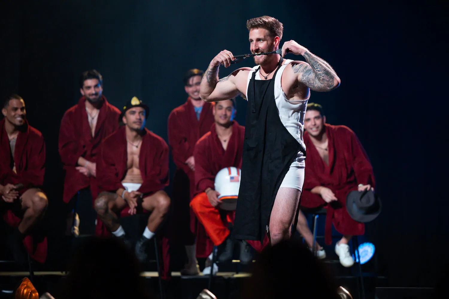 Sam McKinney during a strip tease date in 'The Bachelorette' Season 21. He's walking down a catwalk in front of the other contestants ready to strip.
