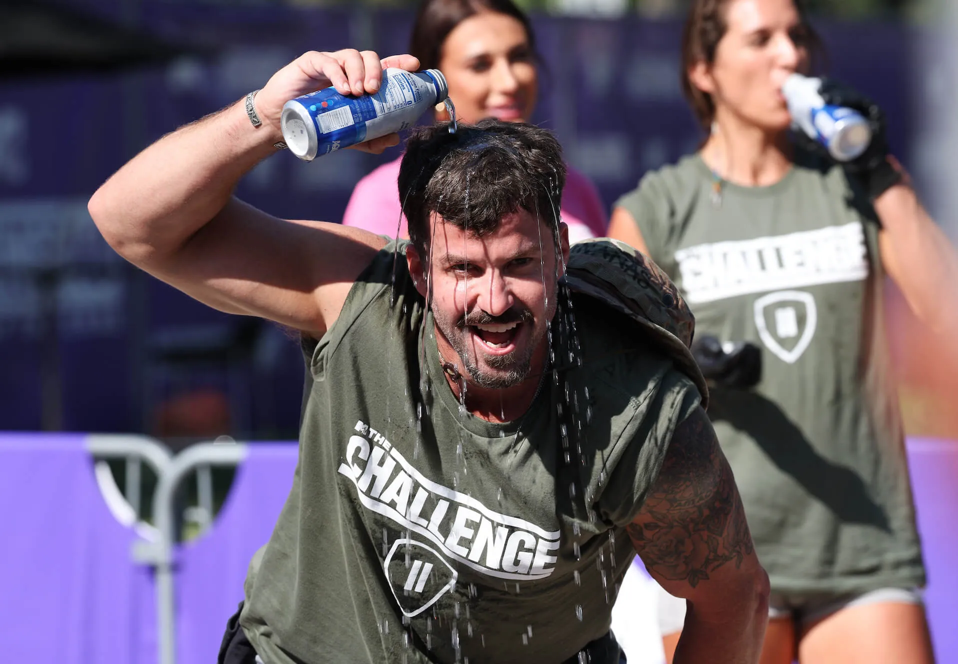 'The Challenge' Season 40 contesant Johnny 'Bananas' Devenanzio smiling while running and pouring a drink over his head