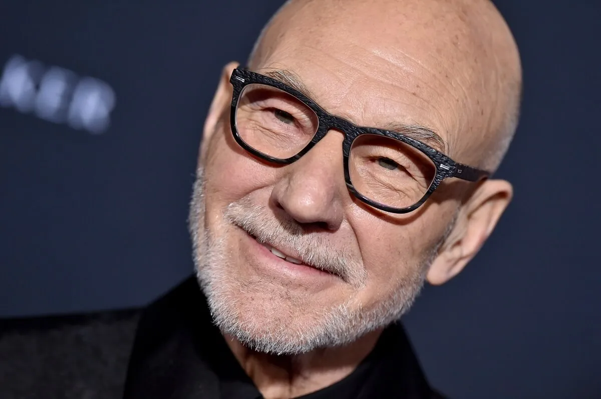 Patrick Stewart posing at the premiere of 'Charlie's Angels' while wearing a black outfit.