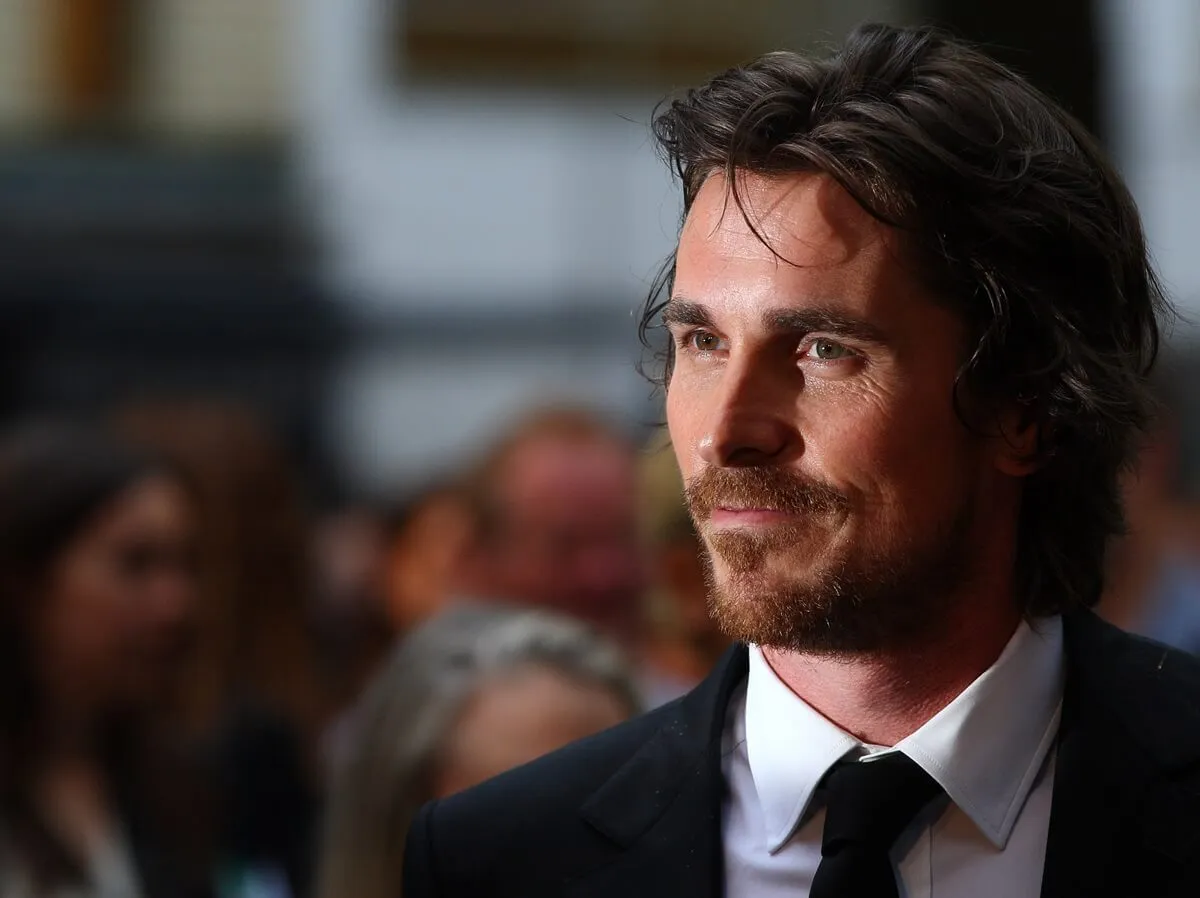 Christian Bale posing in a suit at the premiere of 'The Dark Knight Rises'.