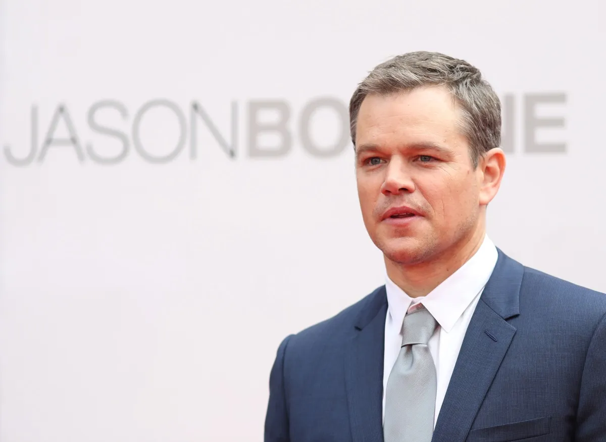 Matt Damon posing in a blue suit at the premiere of 'Jason Bourne'.