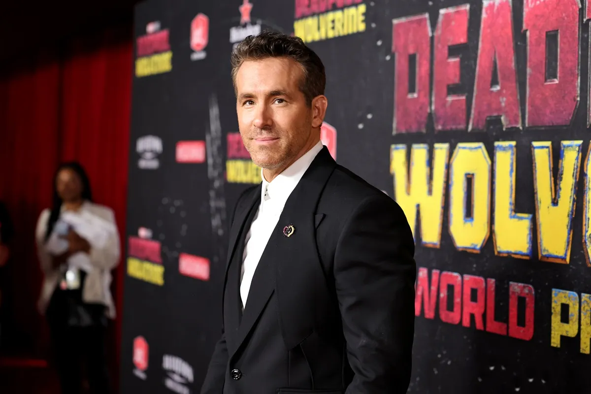 Ryan Reynolds posing in a suit at the premiere of 'Deadpool & Wolverine'.