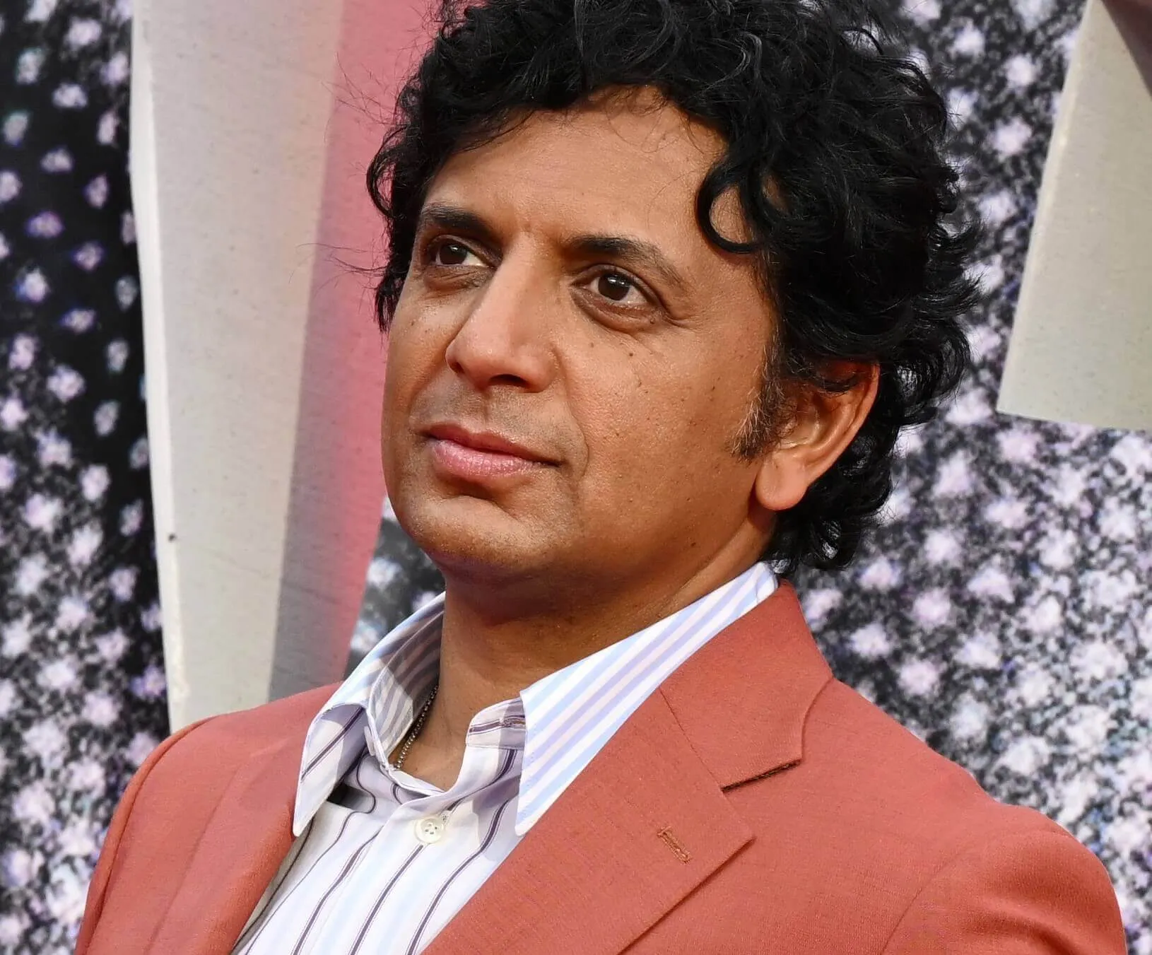 M. Night Shyamalan in a suit while promoting 'Trap'