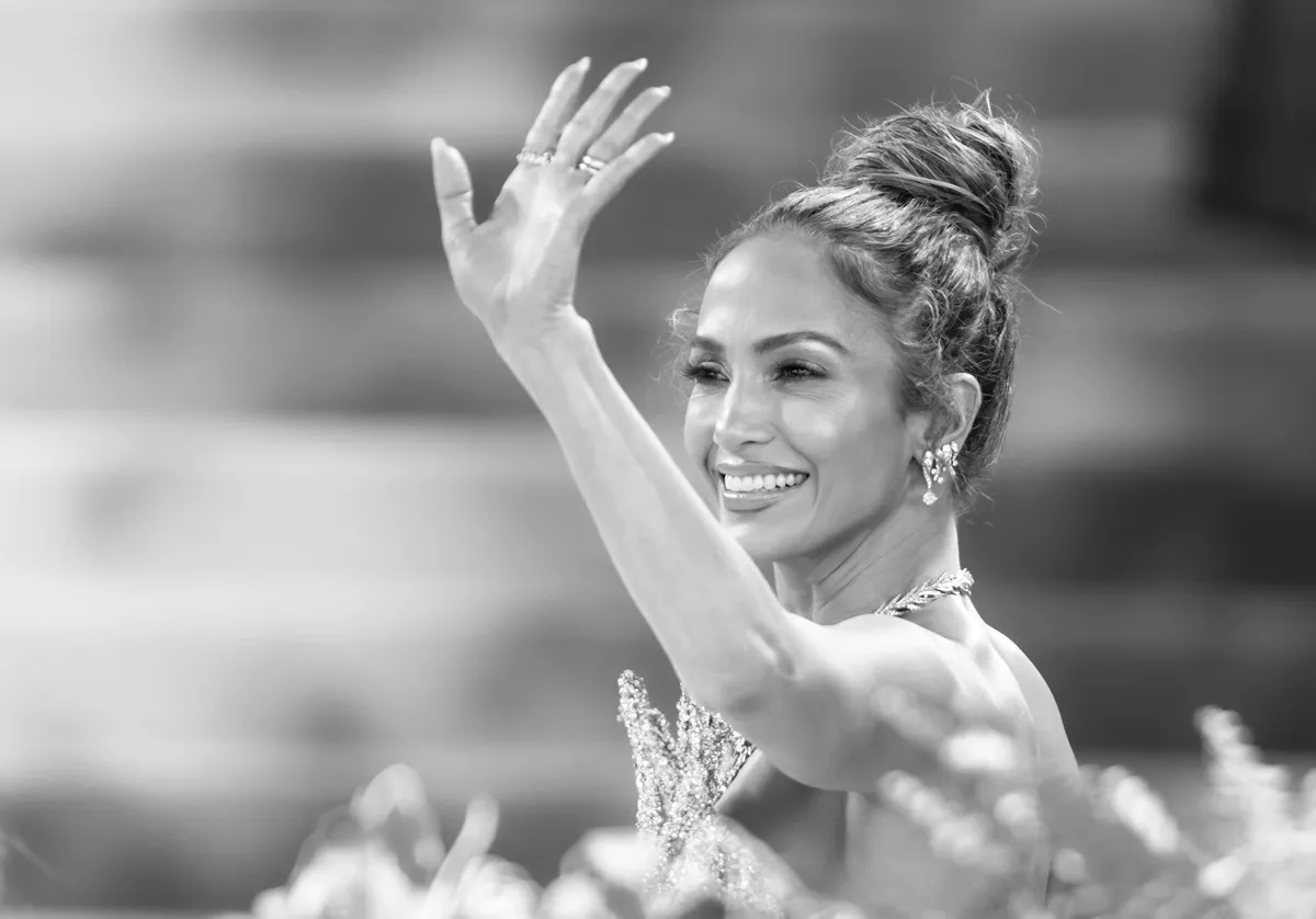 Jennifer Lopez raising her hand in a dress at the 2024 Met Gala Celebrating "Sleeping Beauties: Reawakening Fashion".