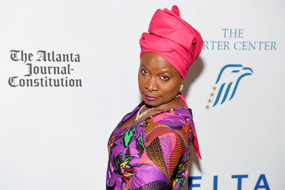 Angelique Kidjo in a colorful dress and pink headwrap