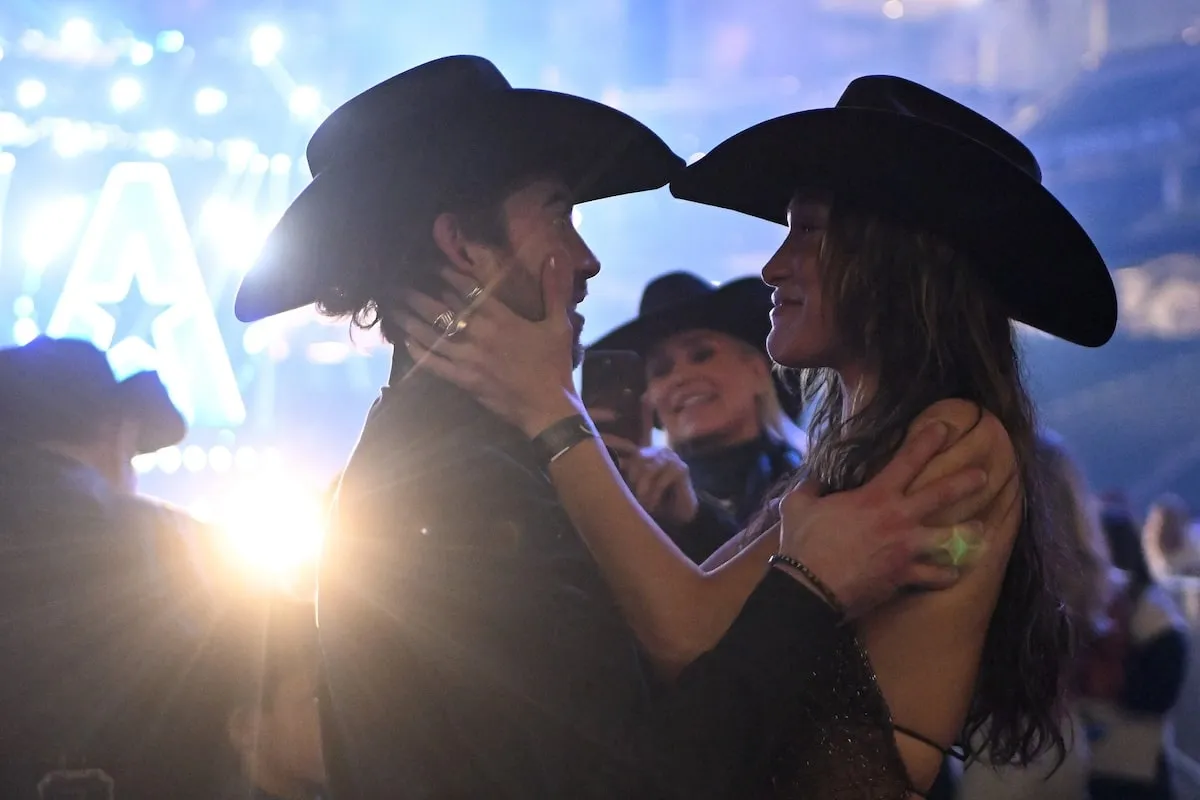 Dating couple Adan Banuelos and Bella Hadid hold each other's faces at The American Performance Horseman