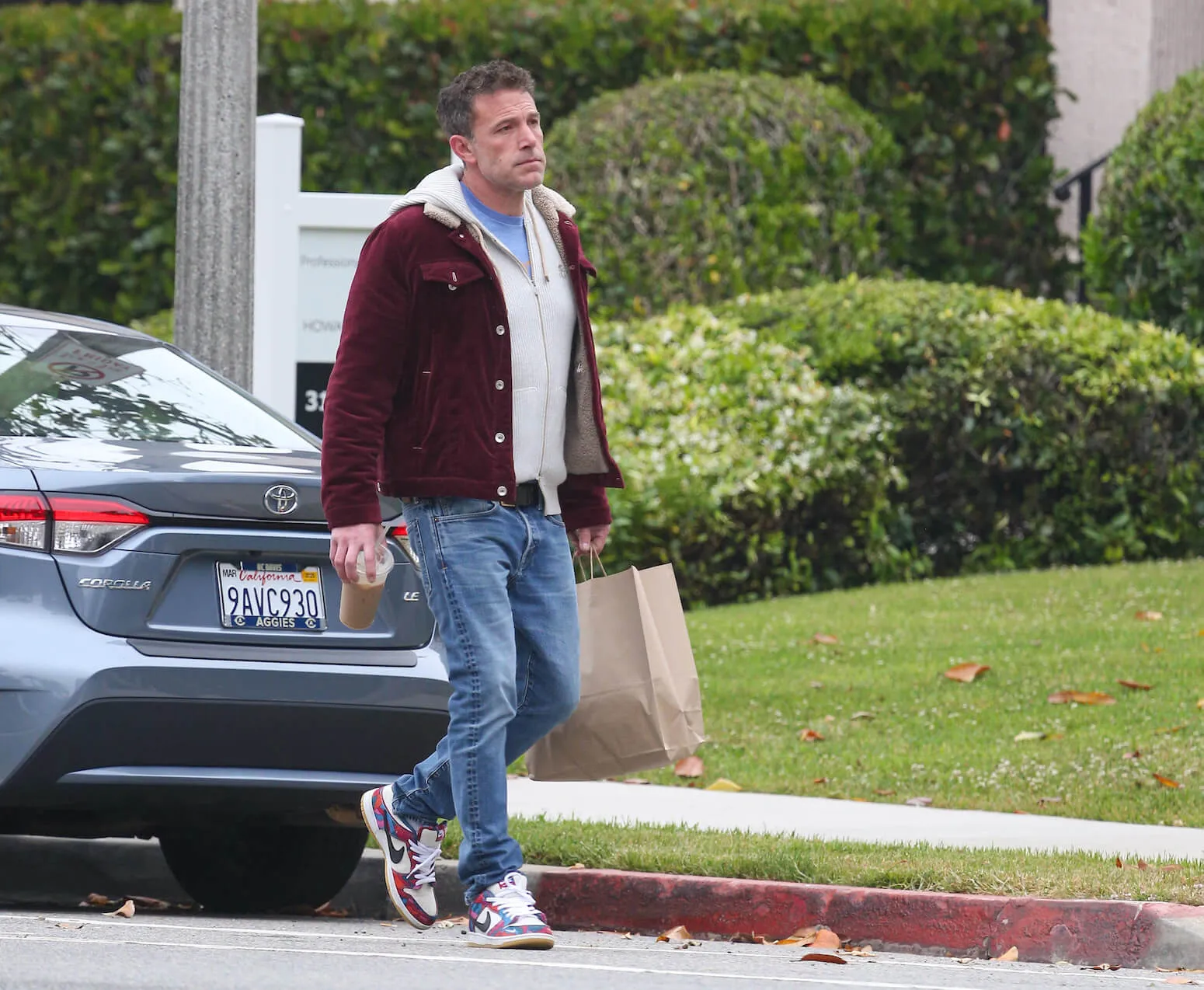 Ben Affleck walking in Los Angeles in May 2024 carrying a bag and an iced coffee