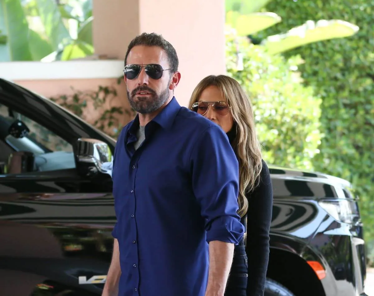 Ben Affleck and Jennifer Lopez stand together outside a car.