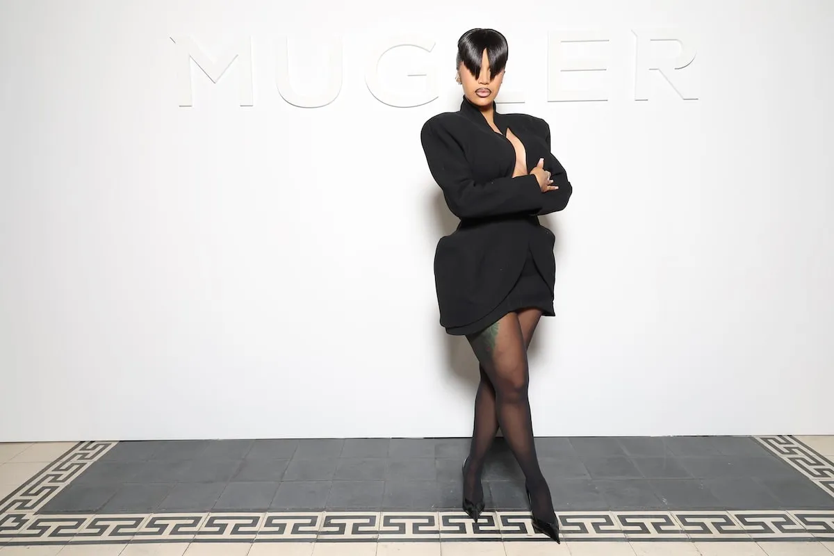 Wearing a black mini dress and blunt bangs, Cardi B poses for photographers before the Mugler spring/summer show 2025 fashion show in Paris