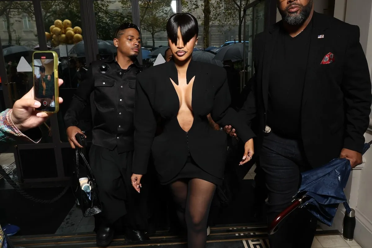 Wearing a black mini dress and blunt bangs, Cardi B poses for photographers before the Mugler spring/summer show 2025 fashion show in Paris