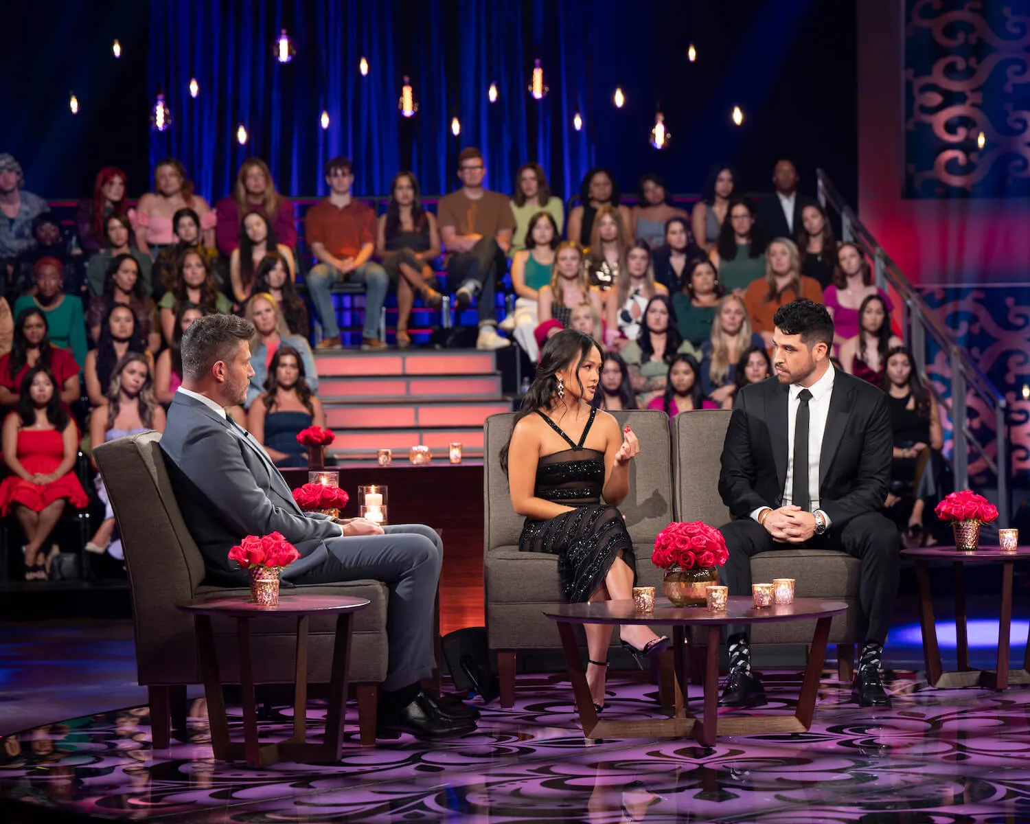 Jenn Tran speaking to Devin Strader on a couch on stage in front of Jesse Palmer in 'The Bachelorette' Season 21 After the Final Rose