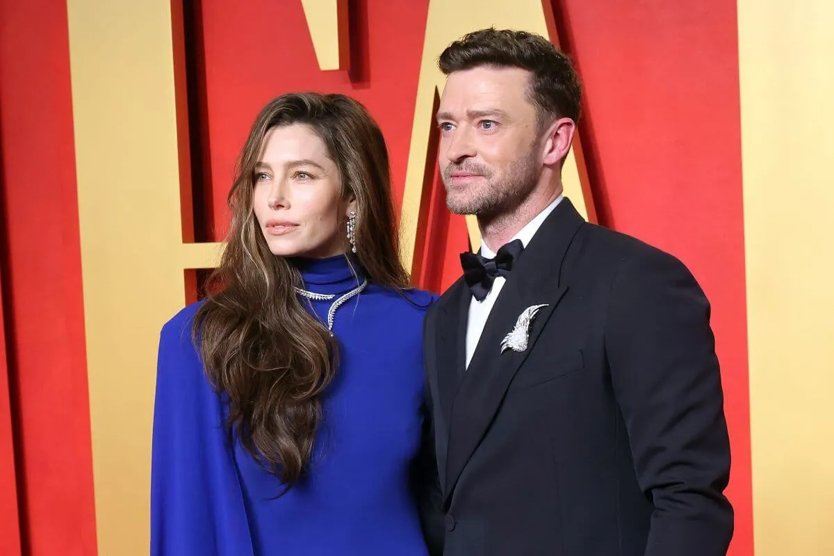 Jessica Biel wears a blue dress and stands with Justin Timberlake, who wears a tuxedo.