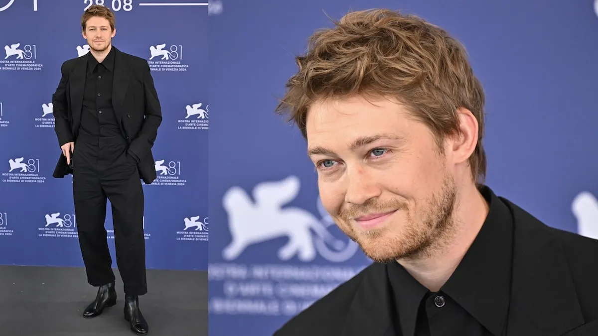 Standing alone on stage, Joe Alwyn attends the "The Brutalist" photocall in a black suit