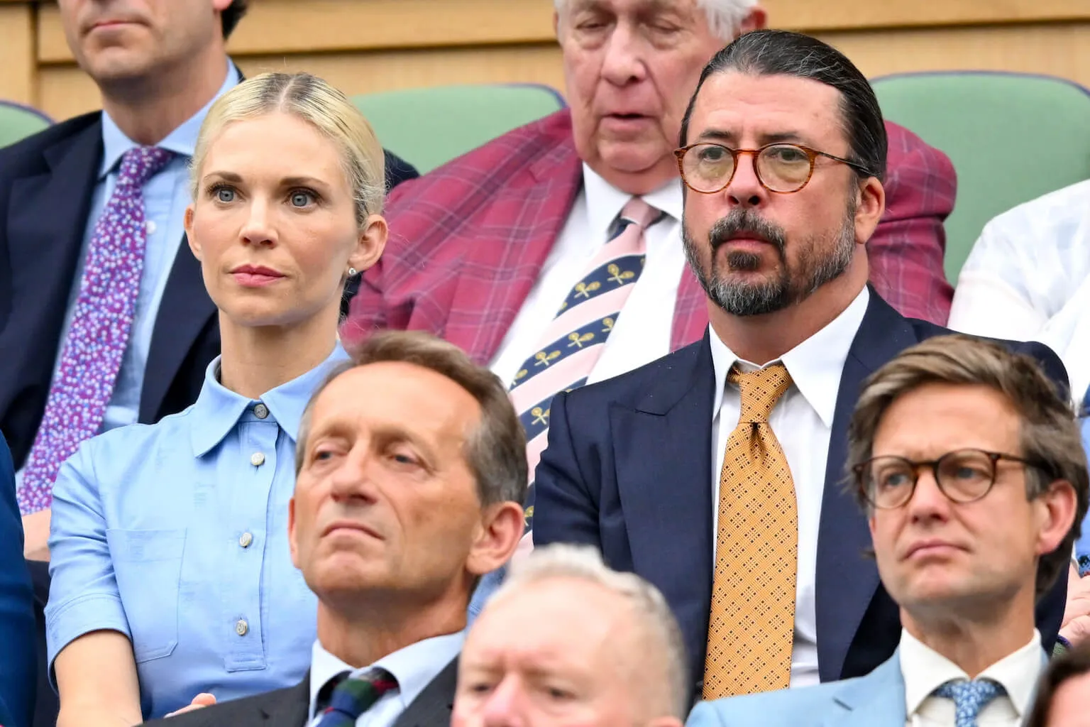 Jordyn Blum and Dave Grohl sitting side by side at Wimbledon in a crowd in July 2024