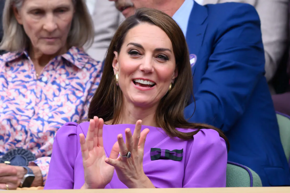 Kate Middleton, who got compared to Princess Diana with her Sept. 10 cancer update video, claps wearing a purple dress.