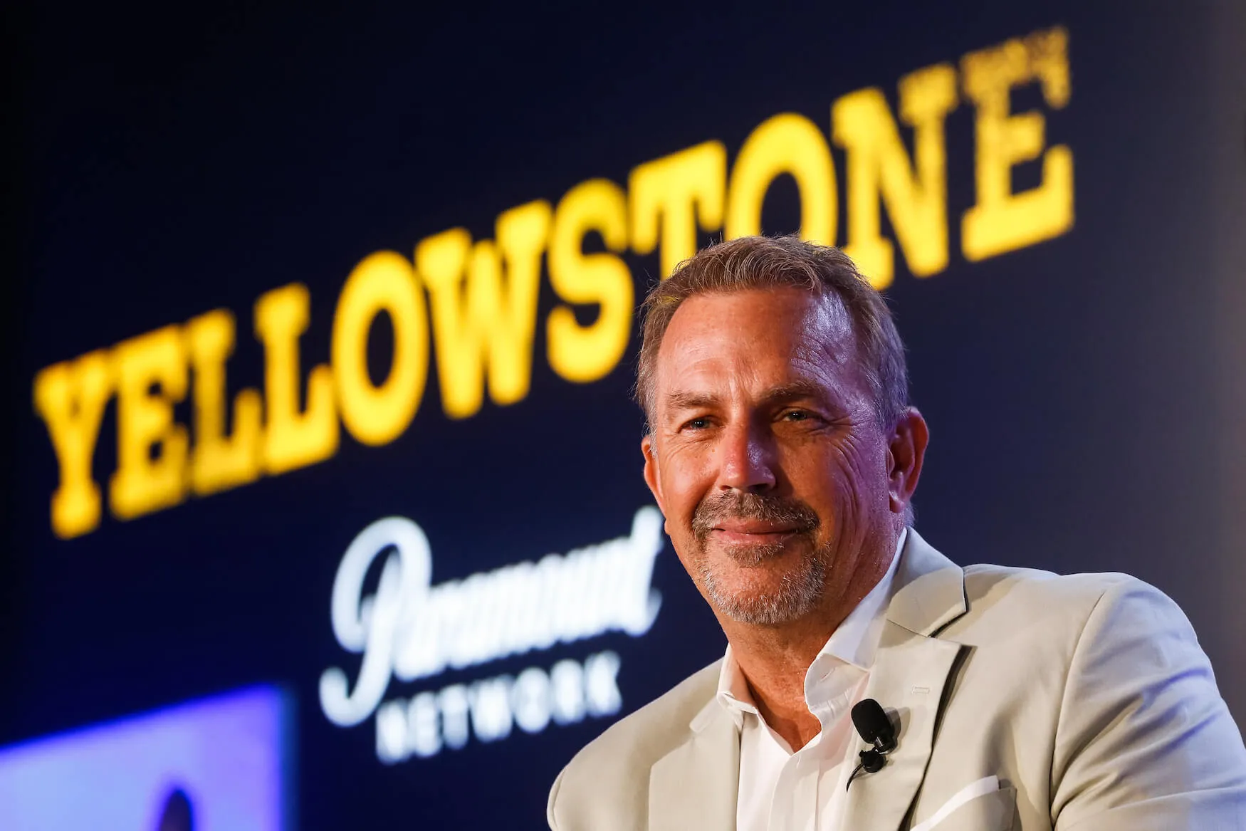 Kevin Costner against a dark background with 'Yellowstone' in yellow across it