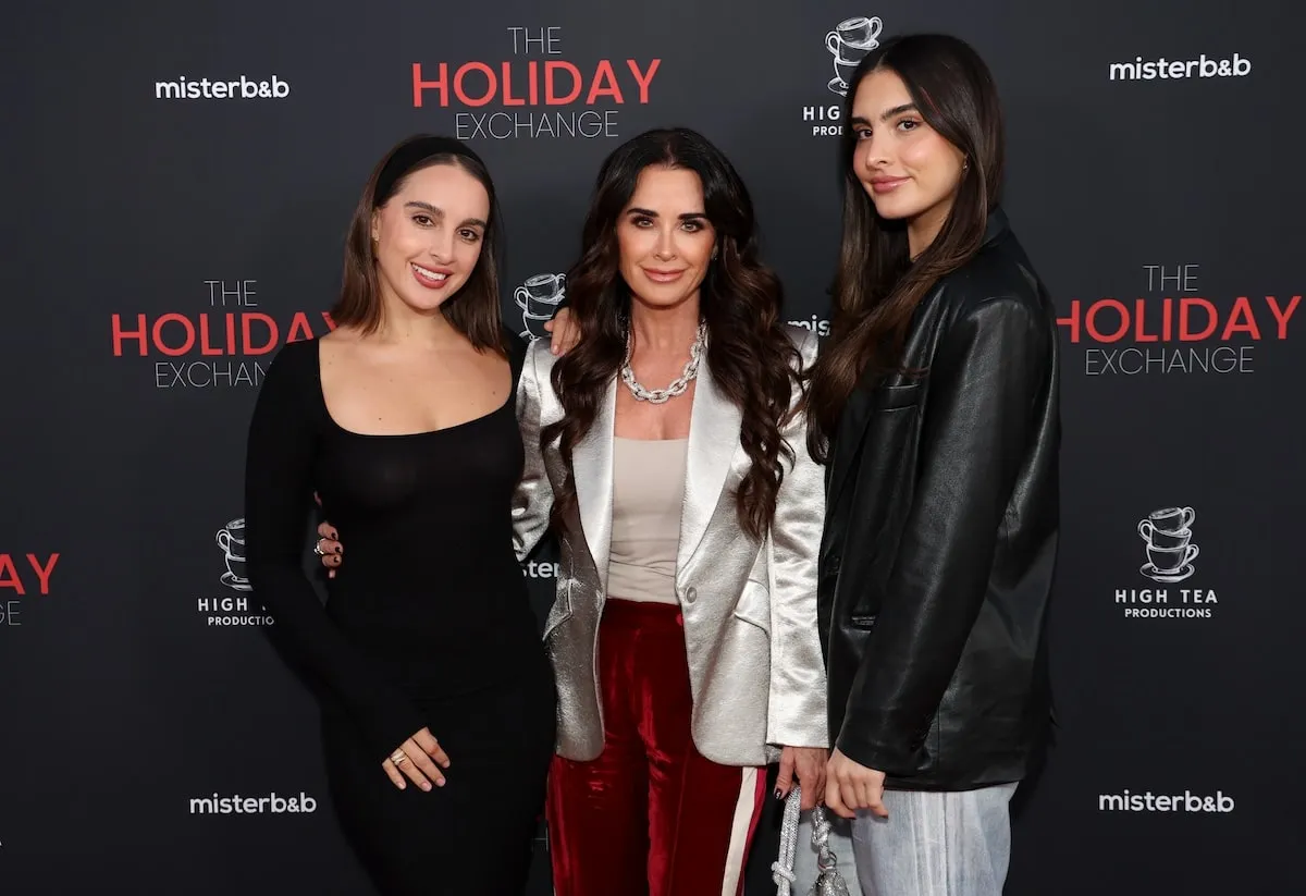 Wearing red, black, and silver, Alexia Umansky, Kyle Richards, and Sophia Umansky attend "The Holiday Exchange" red carpet premiere