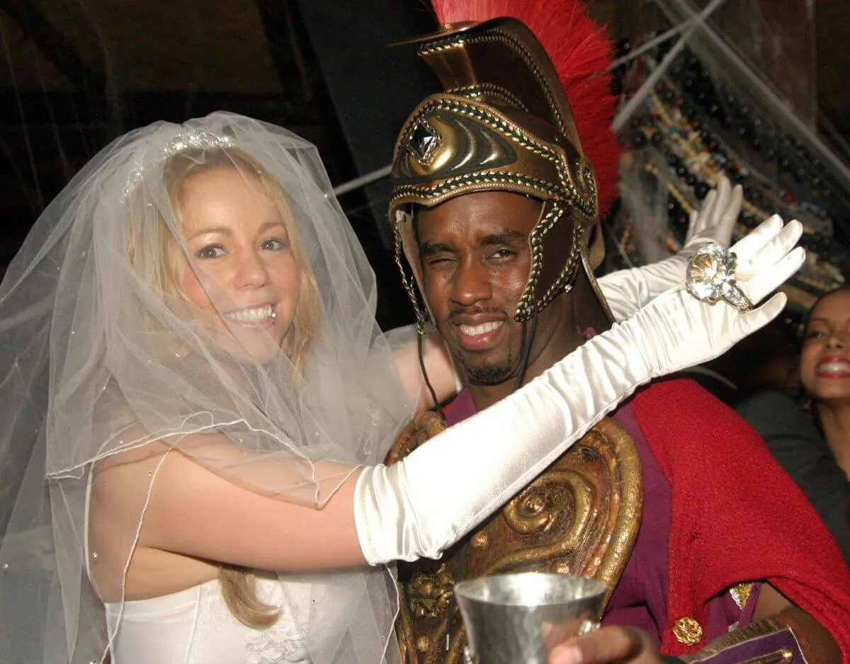 Mariah Carey wears a veil and gloves and has her arms around Sean 'Diddy' Combs, who is dressed as a Roman soldier.