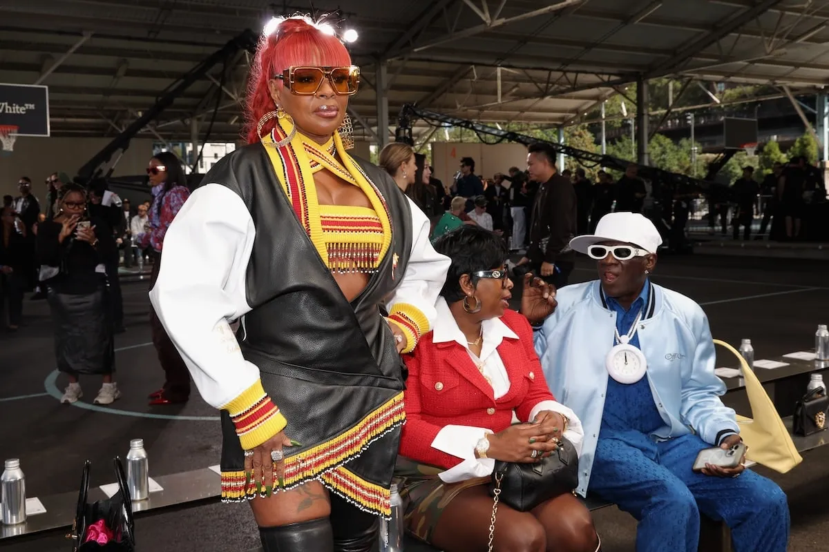 Wearing a black, white, and red leather mini dress, Mary J. Blige poses for photographers at the Off-White fashion show