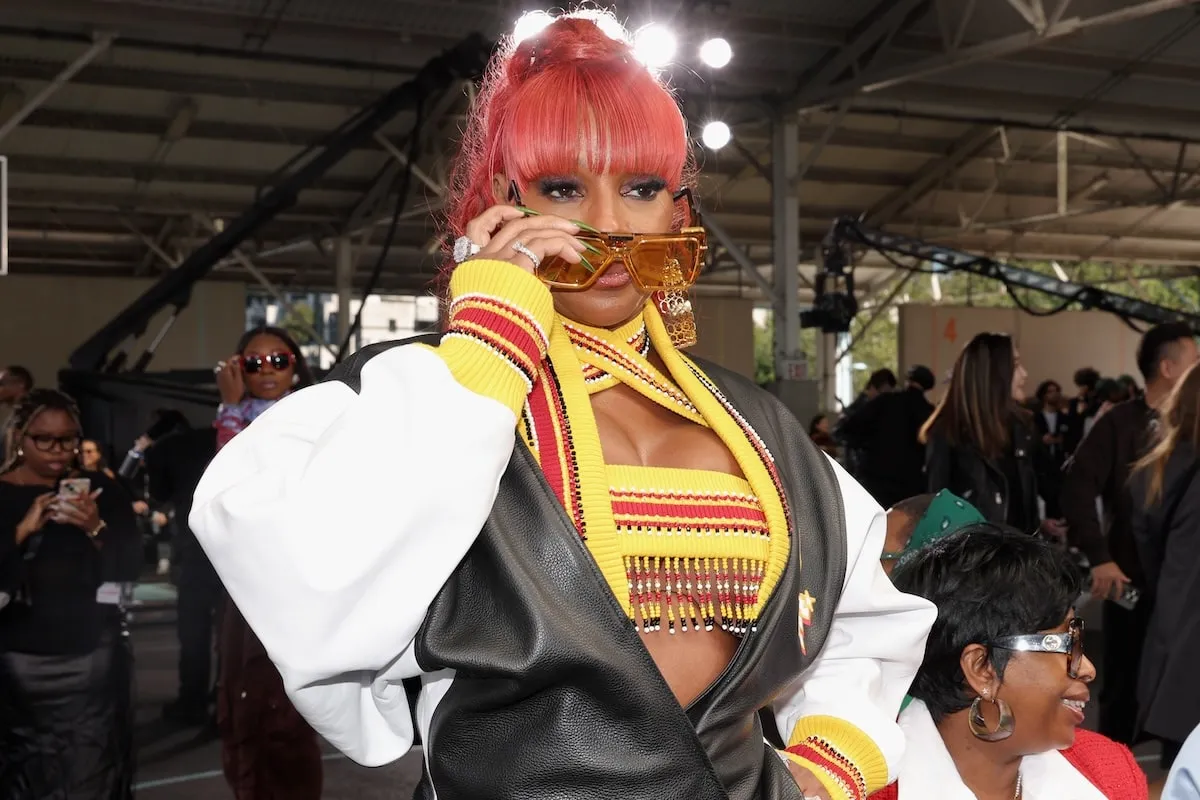 Wearing a black, white, and red leather mini dress, Mary J. Blige poses for photographers at the Off-White fashion show