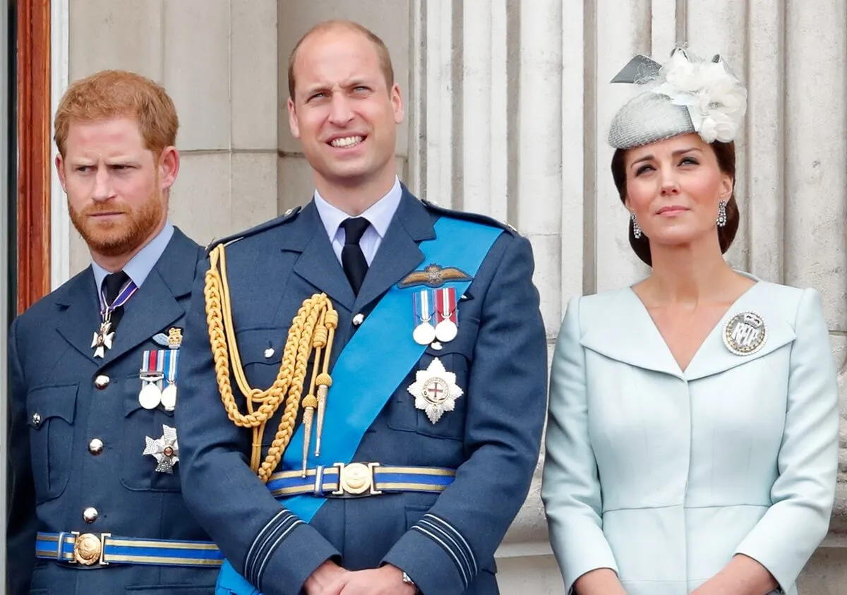 Prince Harry, Prince William, and Kate Middleton watch watch a flypast to mark the centenary of the Royal Air Force from the balcony of Buckingham Palace