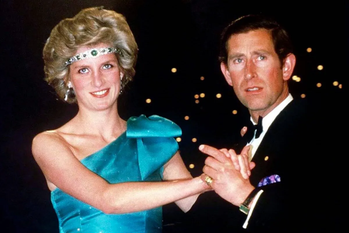 Princess Diana wears a choker necklace as a headband as she dances with King Charles