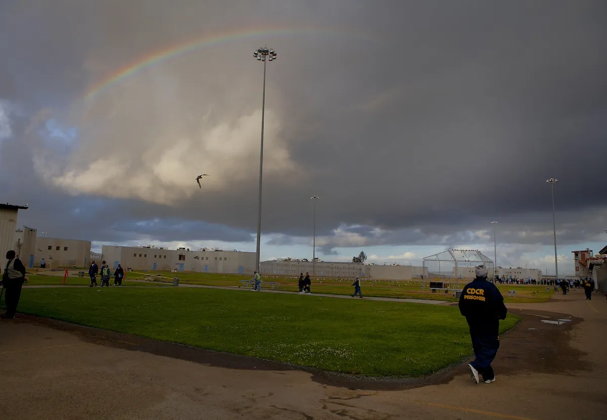 A prison yard with a rainbow overhead