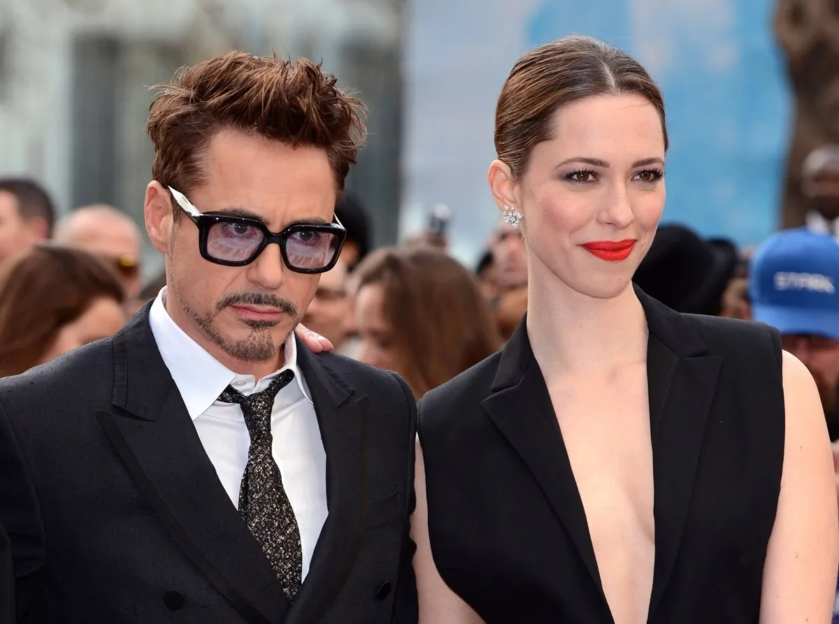 Robert Downey Jr. in a suit posing next to Rebecca Hall at the premiere of 'Iron Man 3'.