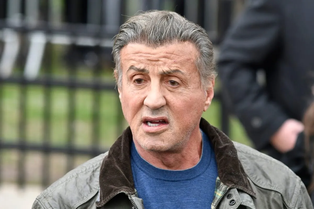 Sylvester Stallone visits the Rocky statue at the Philadelphia Museum of Art, in Philadelphia, PA wearing a light green jacket and blue shirt.