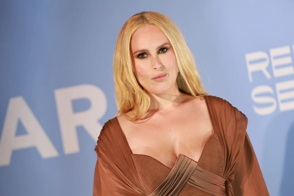 Wearing a bronze draped dress, Rumer Willis poses for the cameras on the red carpet at the amfAR Gala Venezia 2024