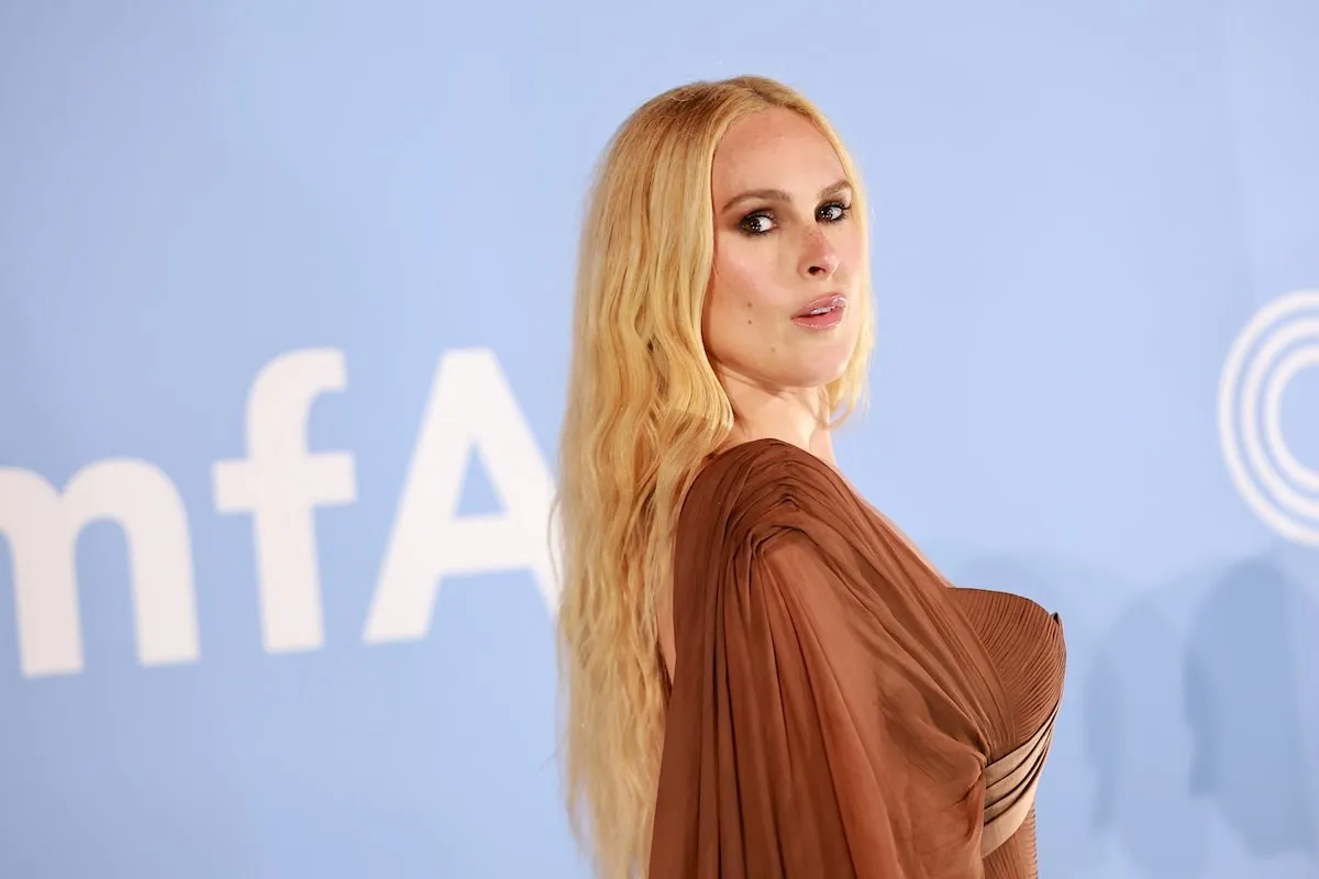 Wearing a bronze draped dress, Rumer Willis poses for the cameras on the red carpet at the amfAR Gala Venezia 2024