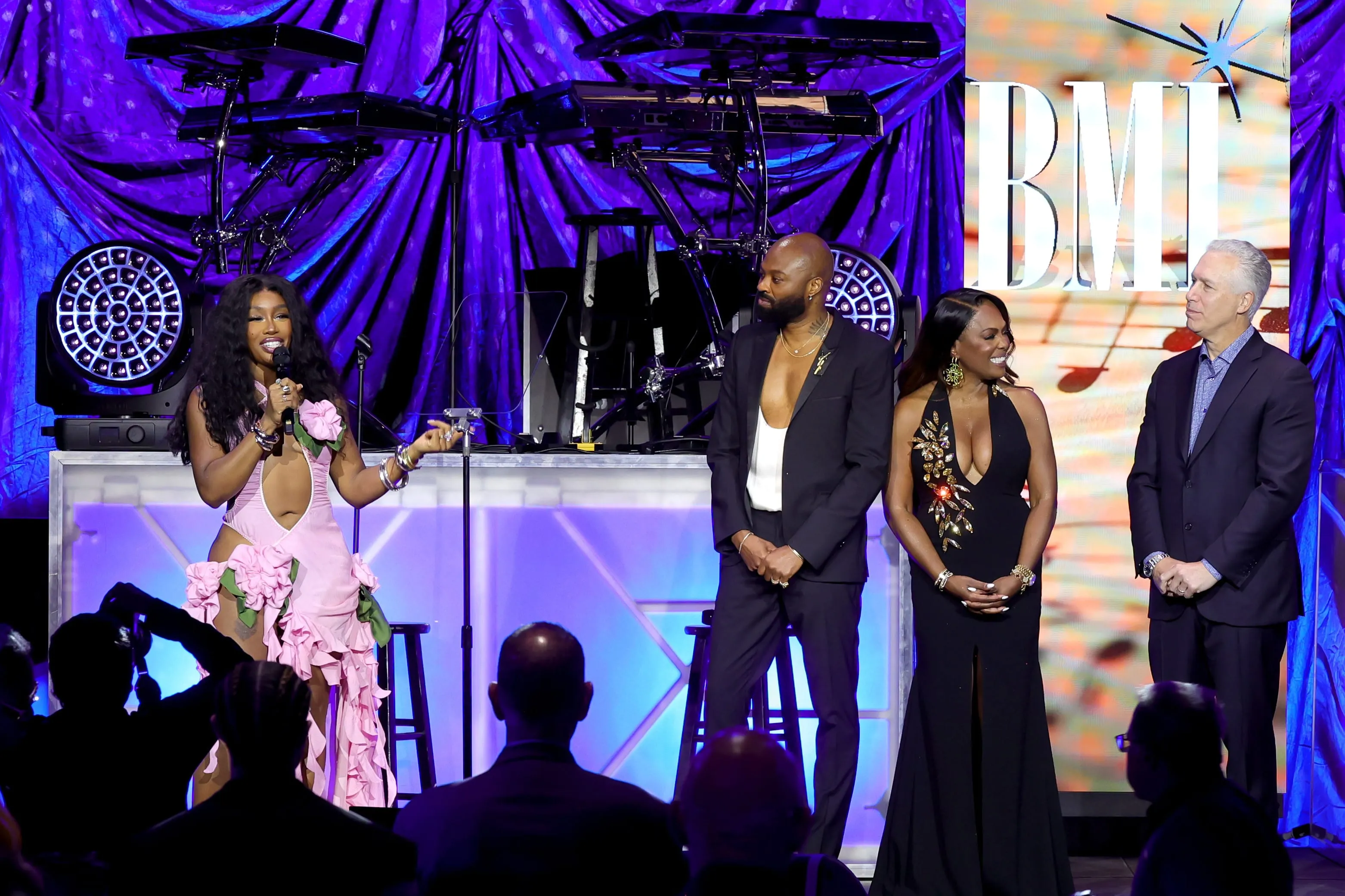 Wearing a pink shredded dress, SZA accepts the BMI Champion Award