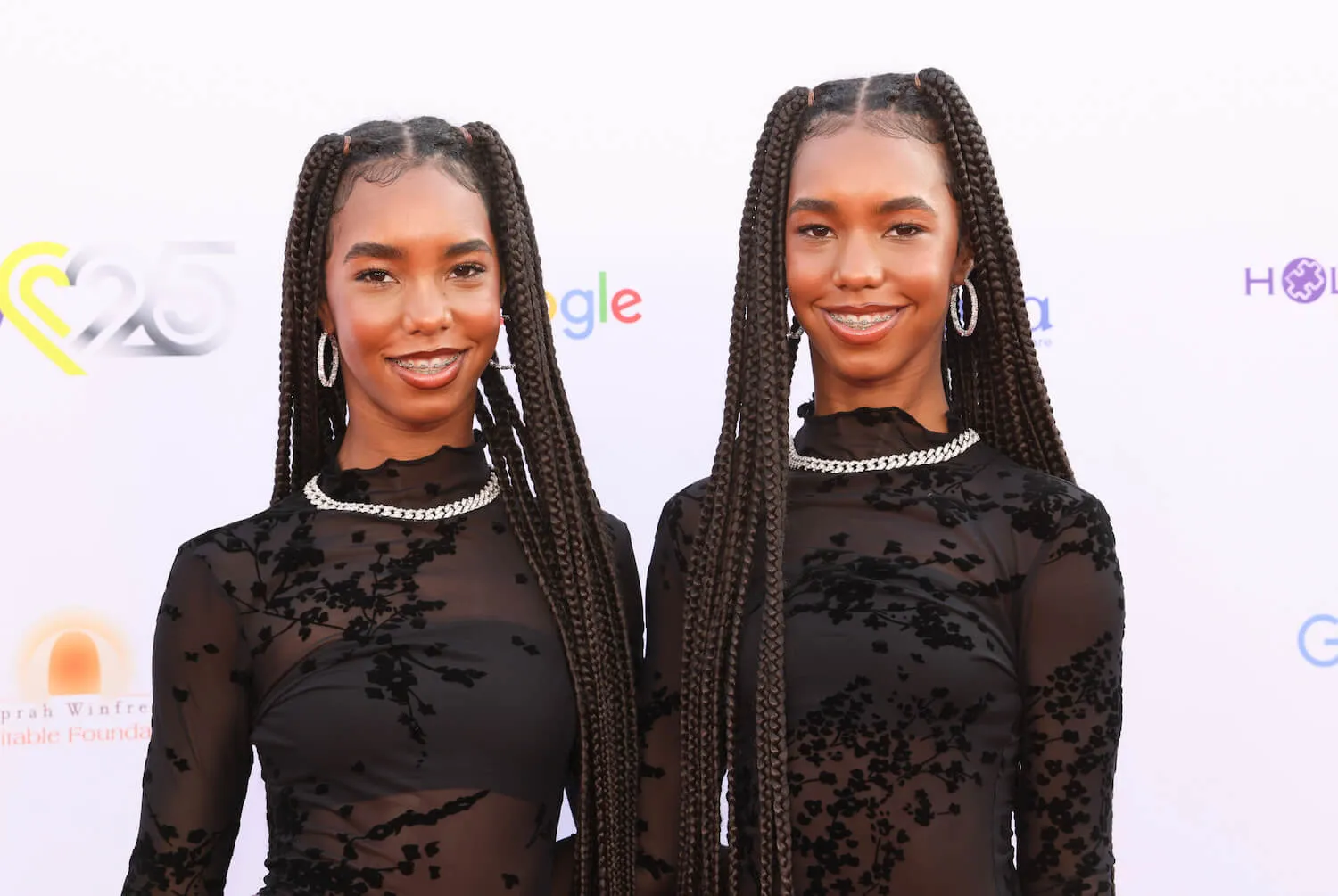 Jessie James Combs and D'Lila Star Combs wearing identical black long-sleeve tops and necklaces as they pose together