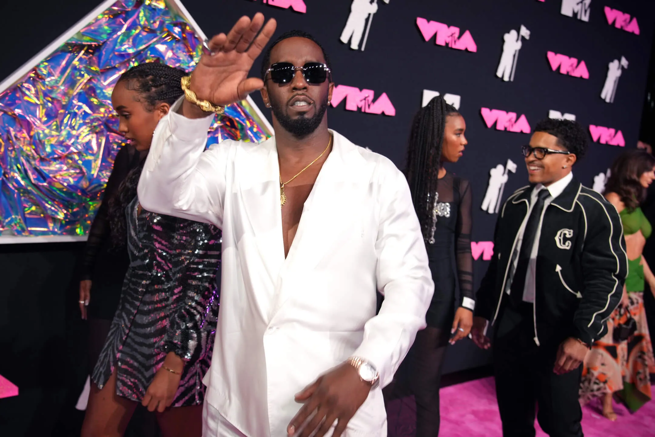 Sean 'Diddy' Combs wearing an all-white outfit and holding a hand up to wave at the MTV Video Music Awards