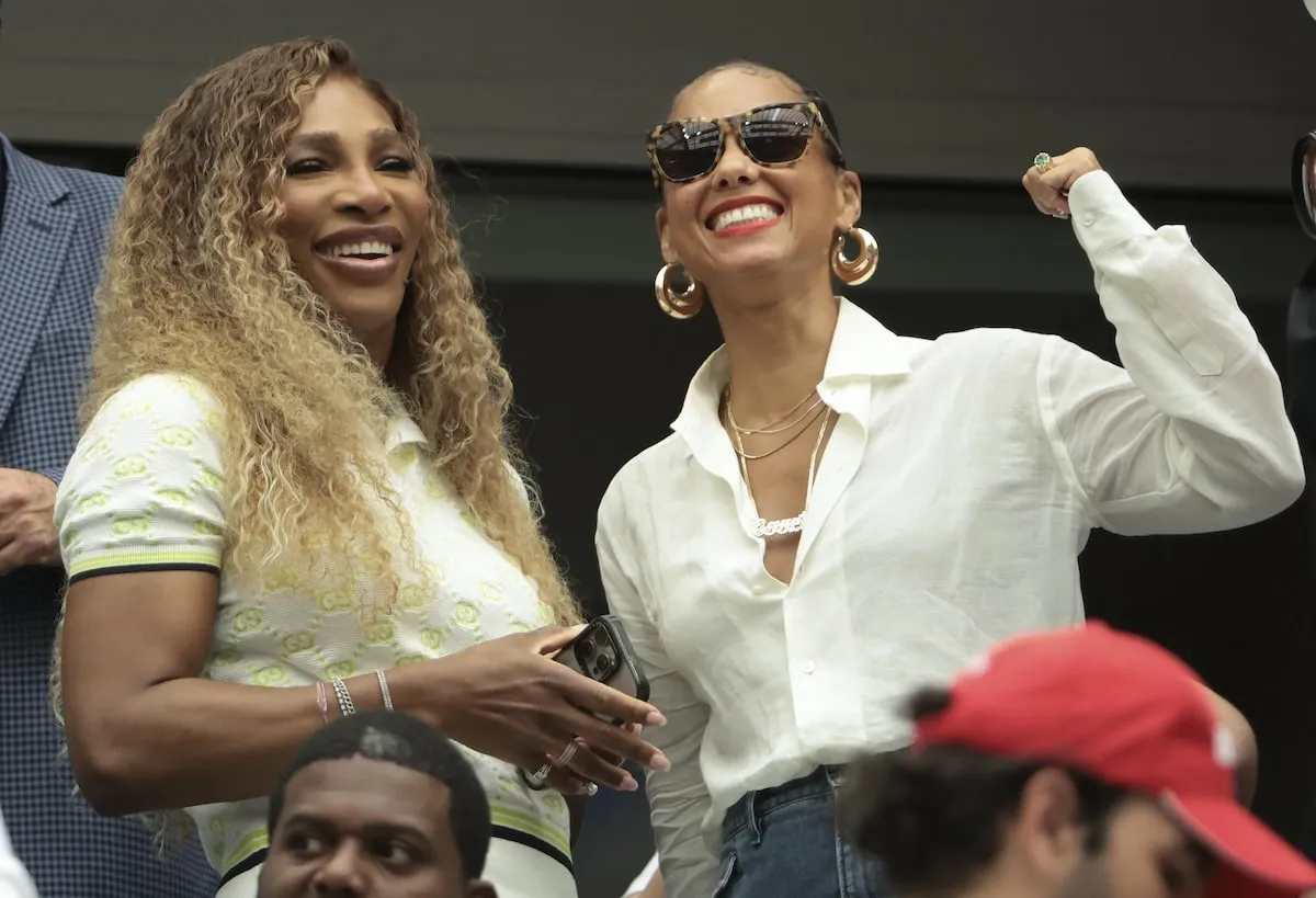 Alicia Keys and Serena Williams stand up next to their seats inside Flushing Meadows and cheer during the U.S. Open