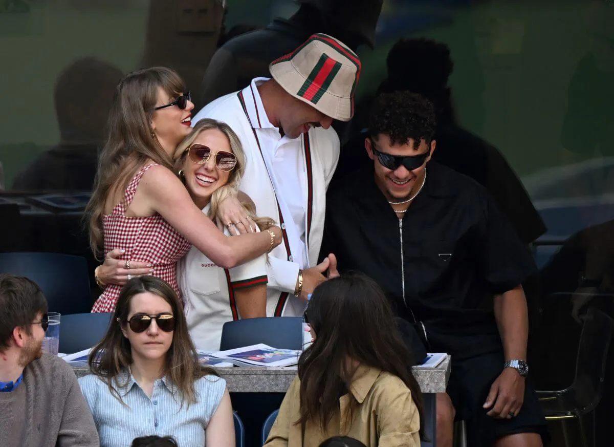 Taylor Swift hugs Brittany Mahomes at the US Open. Travis Kelce and Patrick Mahomes talk next to them.