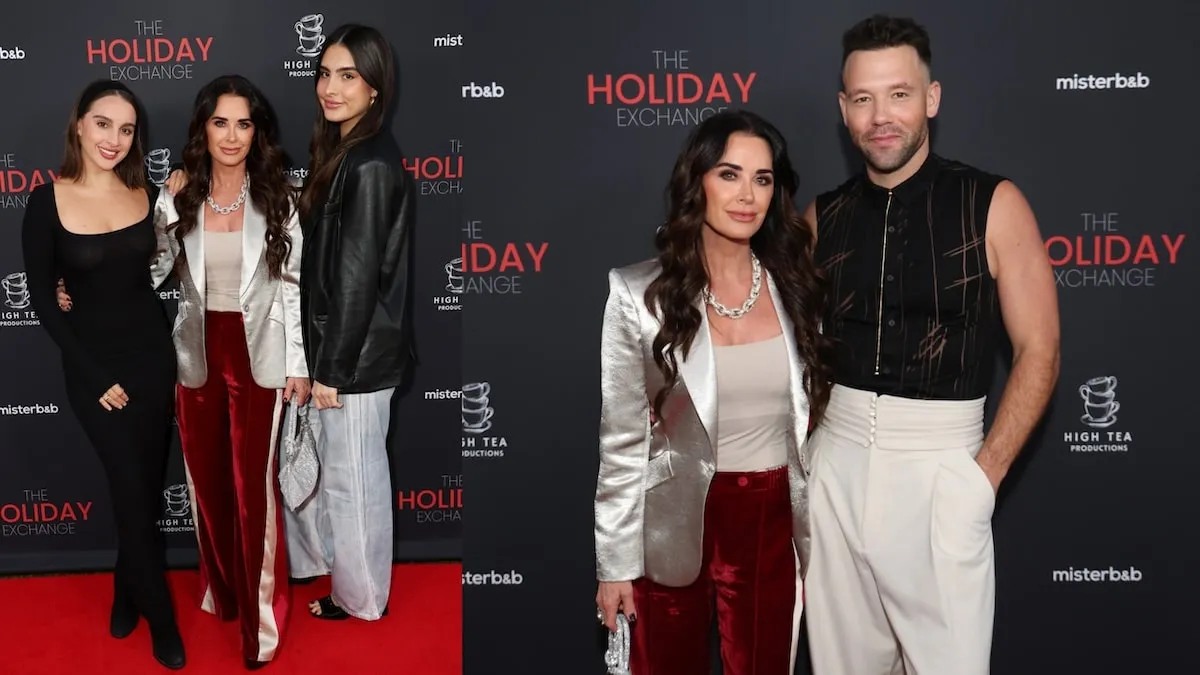 Wearing a silver blazer and red velvet pants, Kyle Richards stands with co-star Taylor Frey on the red carpet at "The Holiday Exchange" premiere