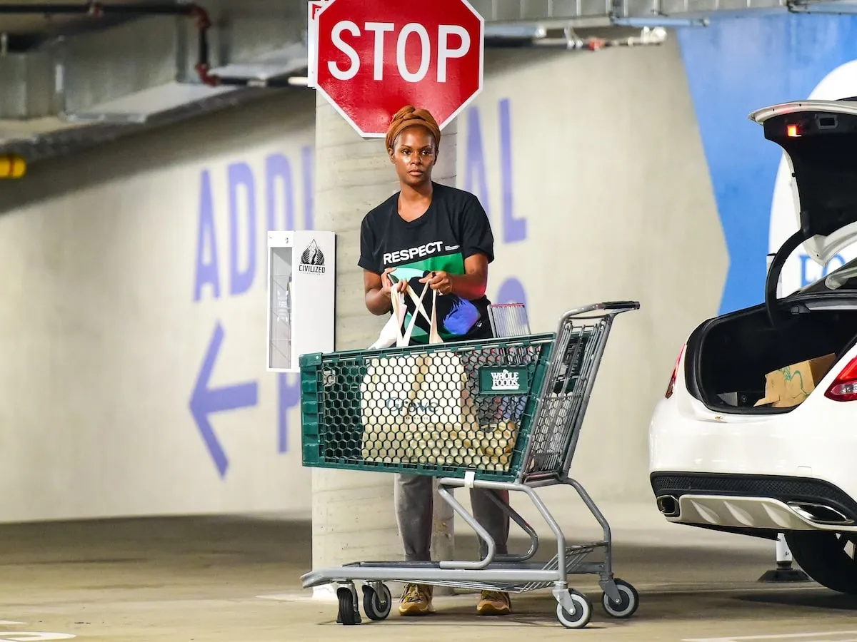 Wearing a tee shirt and jeans, Tika Sumpter grocery shops at Whole Foods in 2021