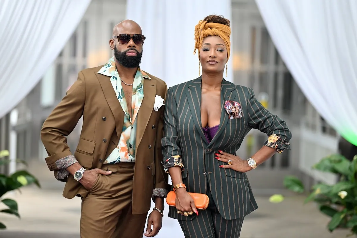 Wearing a gray suit, Toccara Jones and Derek Blanks, wearing a brown suit, stand together before hosting a special charity event in Atlanta