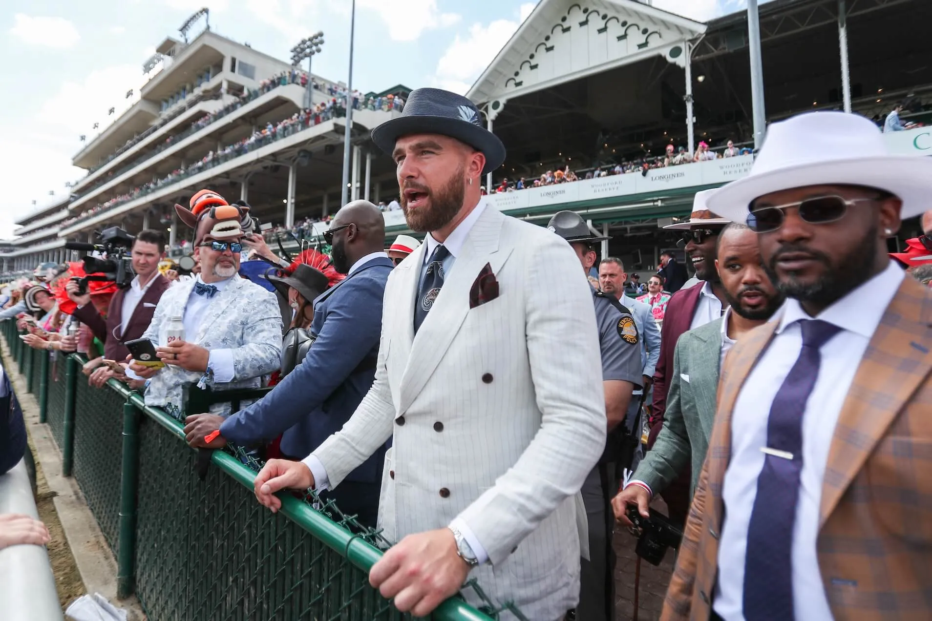 Travis Kelce in a gray suit and hat in a crowd at the 150th Kentucky Derby