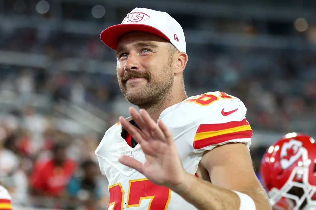 Travis Kelce waves to fans as he leaves the field at halftime during a preseason game