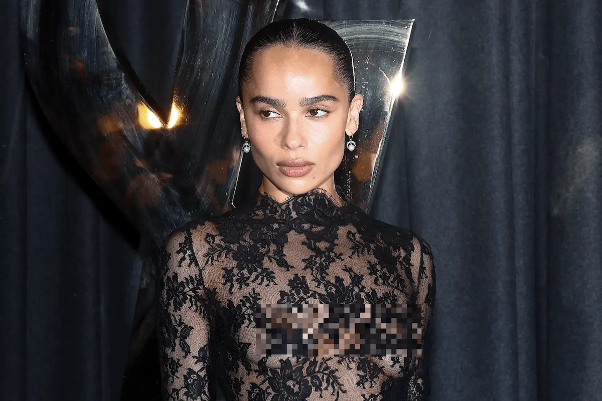 Wearing a sheer black lace mini dress, Zoe Kravitz poses for photos before the Saint Laurent Womenswear Spring-Summer 2025 show